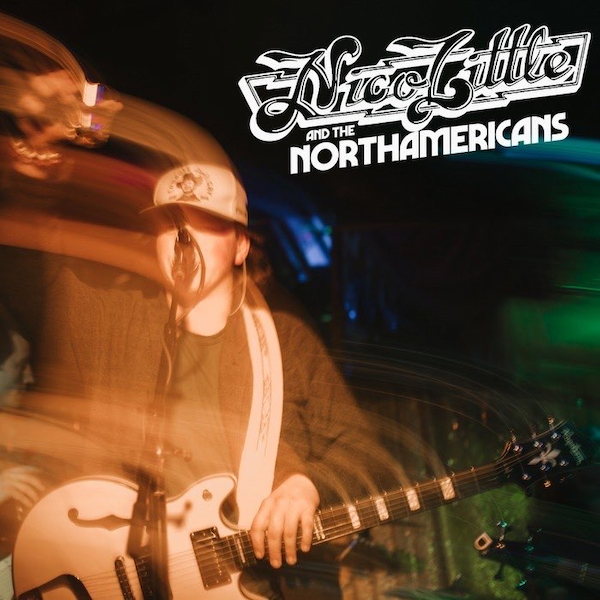 A man playing an electric guitar and singing into a microphone.