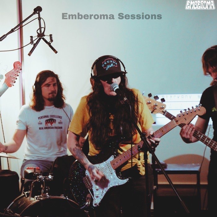 A rock band playing instruments in a studio.