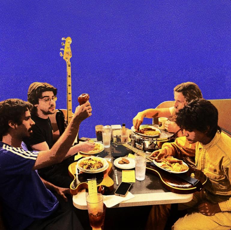 A picture of the band eating food on top of their various instruments.